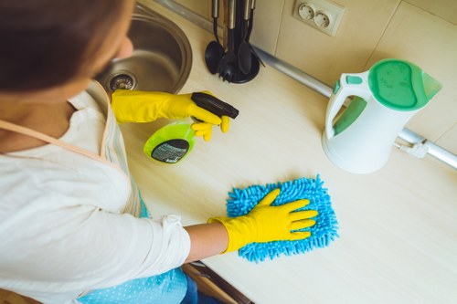 Cleaner sorting recyclable packaging and garment materials in a Balham cleaners workspace